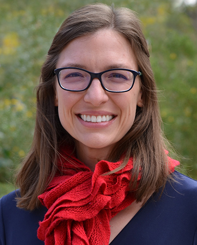 Profile photo of Melissa Wilson outside with red scarf, wearing glasses and smiling.