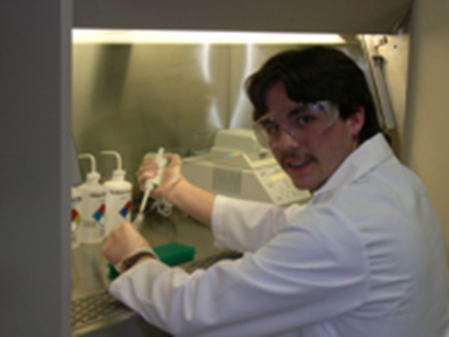 Caleb Marceau using a pipette to prepare specimens under a vent hood.