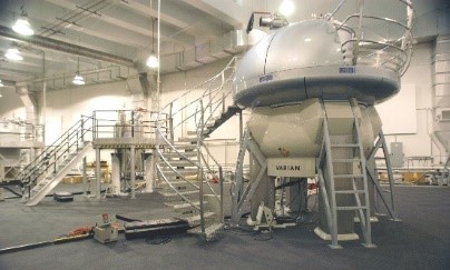 A large white machine with stairs leading up to its upper platform.