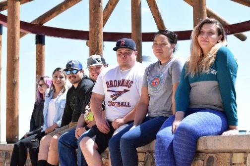 A group of seven college students sitting outside.