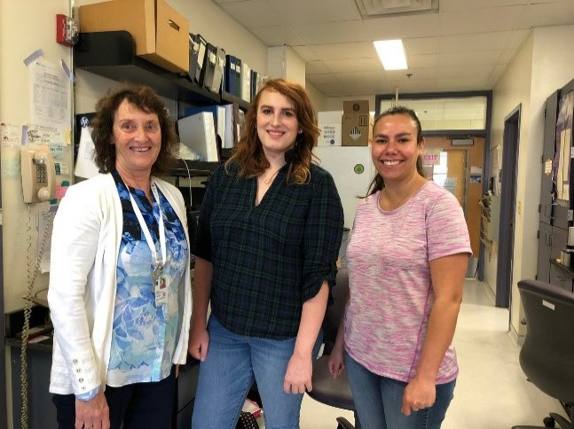 Dr. Wandinger-Ness, Amber Rauch, and Melanie Rivera standing together in a laboratory.