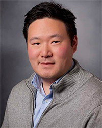 A professional headshot of Dr. Vincent Liu in a button-down shirt and sweater.