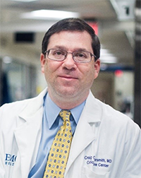 A headshot of Dr. Craig Coopersmith, wearing eyeglasses and a doctor’s coat.