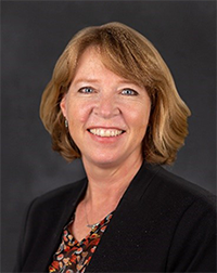 A professional headshot of Dr. Melanie Wright wearing a black blazer.