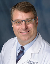 A professional headshot of Dr. Philip Efron, wearing eyeglasses and a doctor’s coat.
