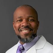 A professional headshot of Dr. Andre Holder wearing a doctor’s coat.