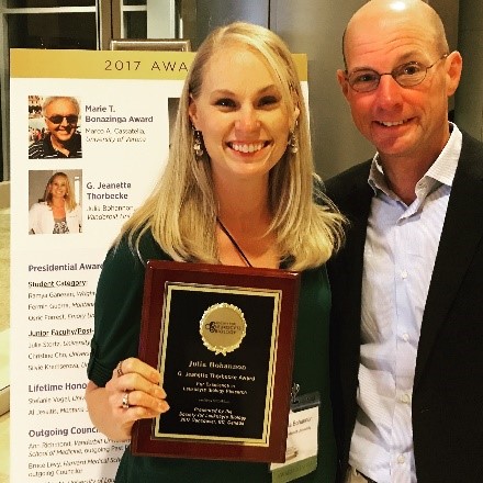 Dr. Bohannon holding an award plaque and standing next to Dr. Sherwood.