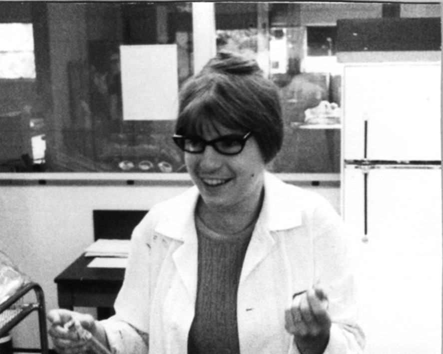 A black and white photo of Dr. Meisler standing in a lab wearing a white lab coat.
