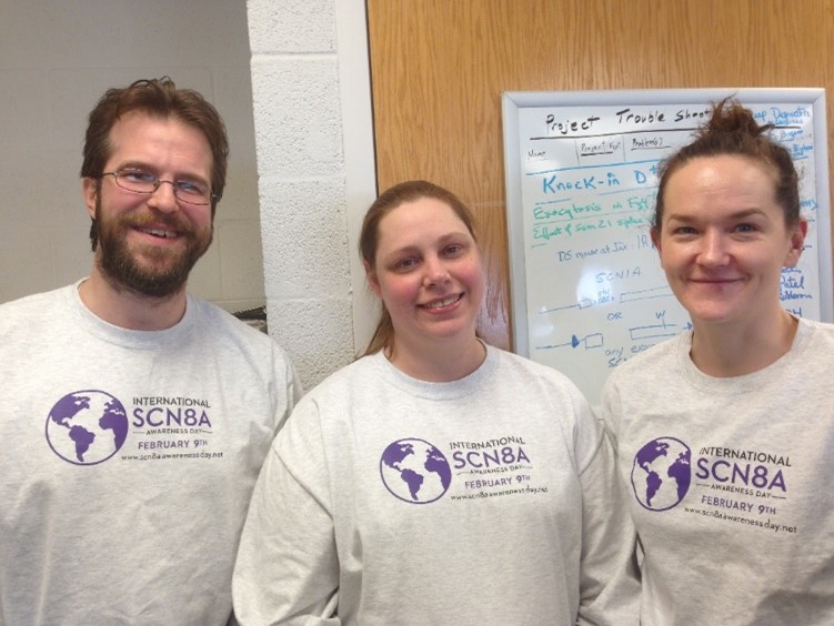 Three people wearing shirts that say “International SCN8A Awareness Day, February 9th, www.scn8aawarenessday.net.”