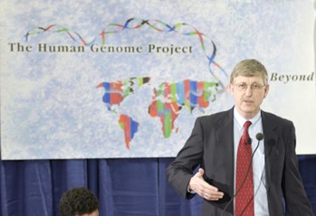 Dr. Francis Collins standing at a microphone in front of a board that says, The Human Genome Project ... Beyond.