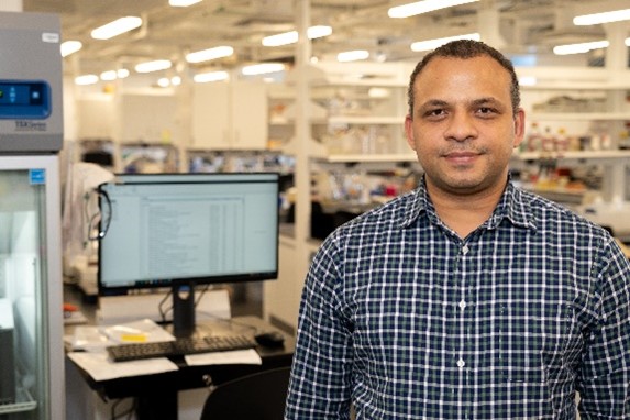 Dr. John Jimah standing in a lab.